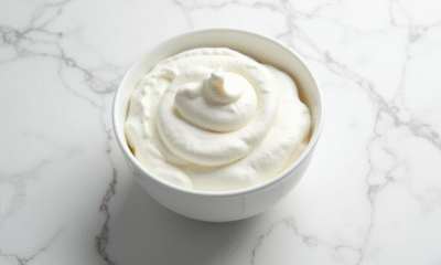 Bol de crème fouettée fraîche vue du dessus sur marbre