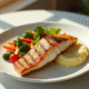 Filet de poisson grillé avec légumes et purée sur une assiette blanche